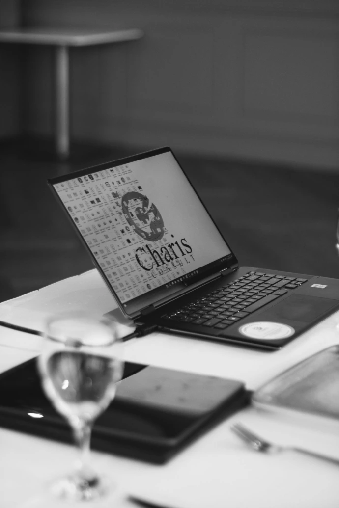 Laptop with charis logo on screen at table